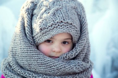 Kışın başörtüsü takan küçük bir kızın portresi.