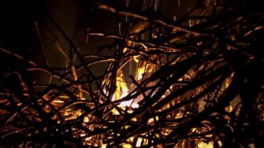 View of a burning bonfire with sparks at night.