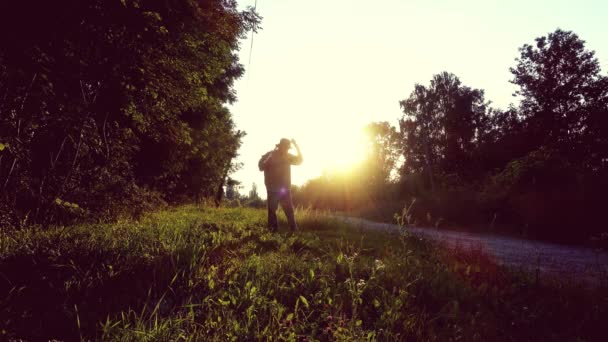 Een Man Maait Het Gras Met Een Handzeis Silhouet — Stockvideo