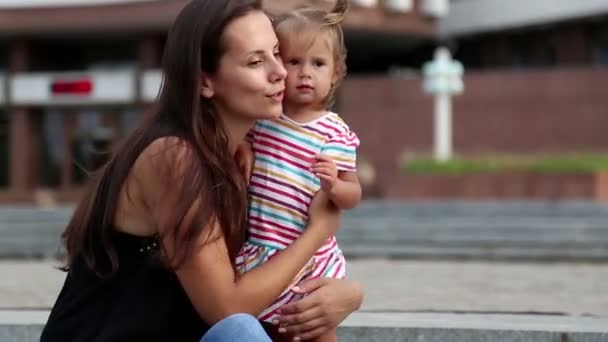 Porträtt av en ung mamma med en child.young mamma på en promenad i staden. — Stockvideo