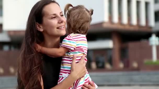 Portrait d'une jeune mère avec un enfant.Jeune mère en promenade dans la ville . — Video