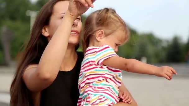 Porträtt av en ung mamma med en child.young mamma på en promenad i staden. — Stockvideo