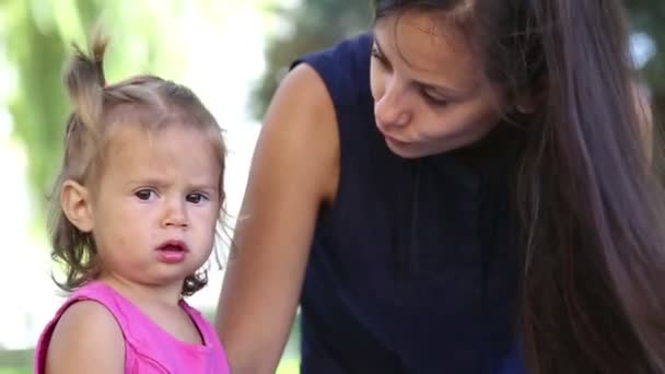 Madre joven con el bebé en un parque de la ciudad.Madre jugando con el bebé en el parque en la pradera. Familia en el parque de vacaciones. Mamá con una niña en la naturaleza . — Vídeo de stock