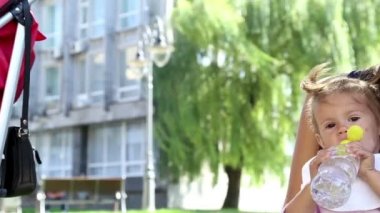 genç güzel anne park.young anne ile bebek yemeği çocuk park.the çocuk annem yanındaki parkta küçük kız yiyor grass.mom yayınları üzerinde muz yayınları.