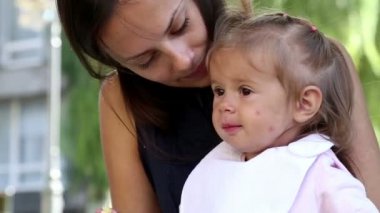 genç güzel anne park.young anne ile bebek yemeği çocuk park.the çocuk annem yanındaki parkta küçük kız yiyor grass.mom yayınları üzerinde muz yayınları.