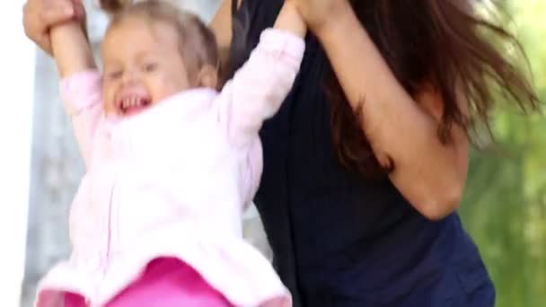 Portrait d'une jeune mère avec bébé à portée de main au parc. Jeune mère avec bébé dans un parc de la ville.Mère joue avec bébé dans le parc sur la pelouse. Maman avec une petite fille dans la nature . — Video