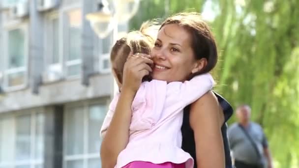 Портрет молодой матери с ребенком на руках в парке. Молодая мама с младенцем в городе, играющая с младенцем в парке на природе. . — стоковое видео
