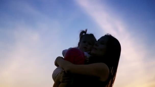 Maman jouant avec bébé au coucher du soleil.Jeune mère jouant avec bébé au coucher du soleil.Maman avec bébé sur fond de ciel . — Video