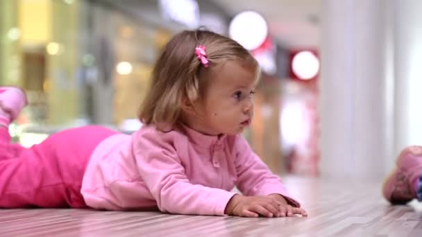 Niña en un supermercado.Niña jugando en el suelo en el centro comercial chopin.Portrait de la niña niño en el playroom.Little niña en un vestido rosa . — Vídeos de Stock