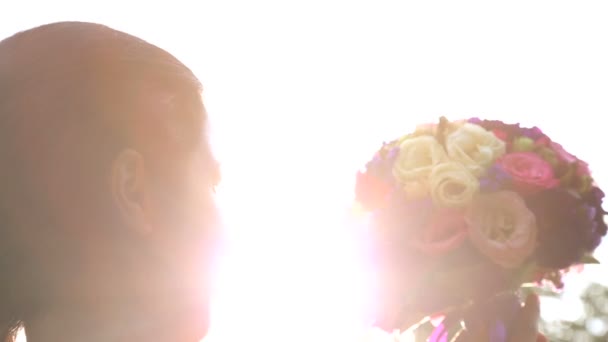 Brudbukett i sunshine.wedding buketten i händerna på bruden på sunset.girl med massa blommor i solljus. — Stockvideo