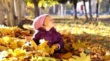 Sonbahar parkta oynayan küçük çocuk. Sarı ile oynayan bebek bırakır. Sonbahar park açık havada, küçük kız. Sonbahar Park bebek portresi.