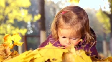 Sonbahar parkta oynayan küçük çocuk. Sarı ile oynayan bebek bırakır. Sonbahar park açık havada, küçük kız. Sonbahar Park bebek portresi.