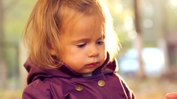 Dítě pije čaj v podzimním parku. Malé dítě je pití čaje v přírodě. Malá holka pije čaj s emocionálně hrnky. Podzimní piknik. Detail dětské emoce. — Stock video