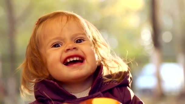 子は秋の公園でお茶を飲みます。小さな子供は、自然の中お茶を飲んでいます。少女は、感情的にマグカップとお茶を飲みます。秋のピクニック。感情の子供のクローズ アップ. — ストック動画