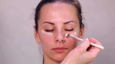 Makyaj yüz kız yakın çekim. Kız portresi bir güzellik salonu kapatın. Yüz, temizlik kozmetik cilt temizliği. Bakımı en büyük planom karşı karşıya. Professionalnaya temizlik cilt.