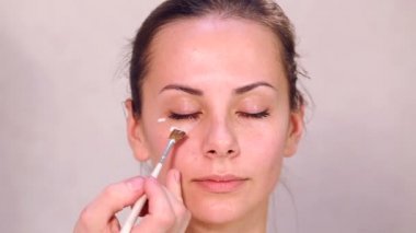 Makyaj yüz kız yakın çekim. Kız portresi bir güzellik salonu kapatın. Yüz, temizlik kozmetik cilt temizliği. Bakımı en büyük planom karşı karşıya. Professionalnaya temizlik cilt.