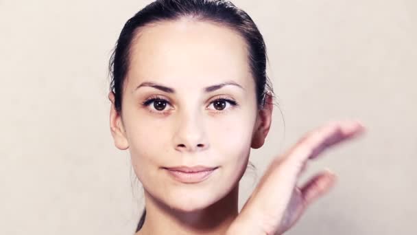 Retrato de uma bela jovem posando na câmera.Rosto de uma bela jovem está fazendo massagem.Exercícios para o rosto, rosto cuidados com a pele.Retrato facial de uma menina close-up . — Vídeo de Stock