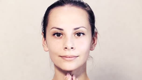 Retrato de uma bela jovem posando na câmera.Rosto de uma bela jovem está fazendo massagem.Exercícios para o rosto, rosto cuidados com a pele.Retrato facial de uma menina close-up . — Vídeo de Stock