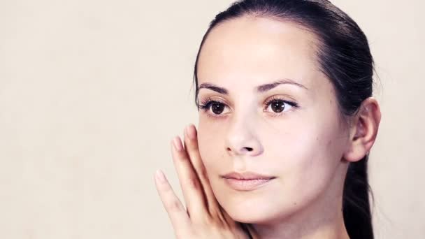 Retrato de uma bela jovem posando na câmera.Rosto de uma bela jovem está fazendo massagem.Exercícios para o rosto, rosto cuidados com a pele.Retrato facial de uma menina close-up . — Vídeo de Stock