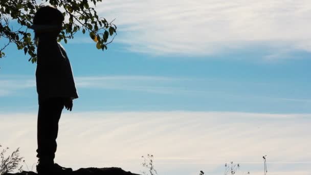 Silhouette di un ragazzo che gioca con un aereo di carta.Ragazzo solitario che gioca all'aperto.Il bambino inizia aereo su sfondo cielo . — Video Stock