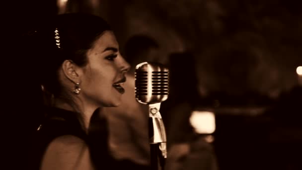 Jovem mulher bonita cantando.A jovem cantora canta no microfone.Close-up retrato da cantora, retro, preto e branco . — Vídeo de Stock