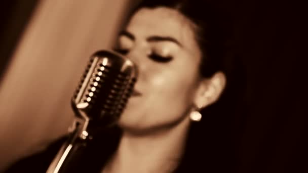 Young beautiful woman singing.The young singer sings into the microphone.Close-up portrait of the singer, retro, black and white. — Stock Video