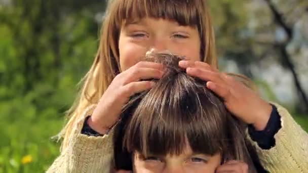 Crianças brincando na grama. Crianças europeias de pele branca lutam na grama verde. Jogos de crianças. Os rapazes entregam-se à natureza. Os rapazes entregam-se à natureza. Menino com cabelo loiro longo se divertindo, rindo e brincando . — Vídeo de Stock