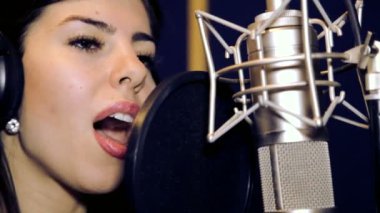 Genç güzel kız şarkı söylüyor. Genç şarkıcı bir mikrofona şarkı. Portre ve şarkıcı kapatın. Kayıt stüdyosu. Kayıt stüdyosu şarkıcılar.