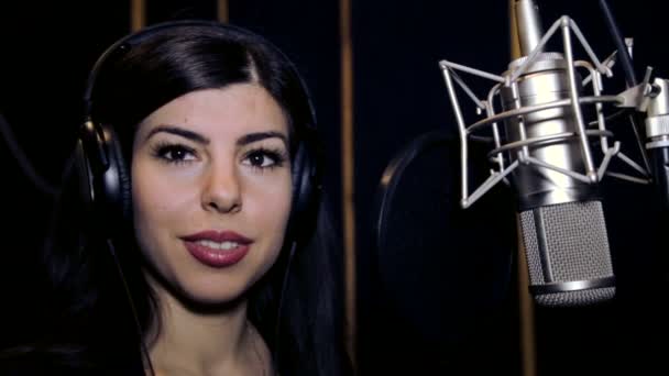 Mooi meisje zingt. Jonge zanger, zingen in een microfoon. Portret van de zangeres close-up. Opnamestudio. Opname in de studio zangers. — Stockvideo