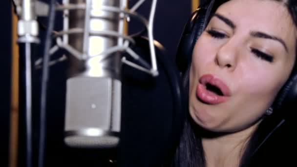Junge schöne singende Mädchen.junge Sängerin, die in ein Mikrofon sind.Portrait der Sängerin in Nahaufnahme .Aufnahme im Studio.Aufnahme im Studio Sänger. — Stockvideo