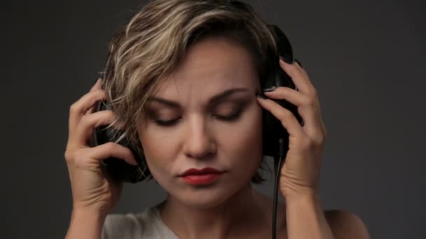 Portrait of beautiful girl in headphones. Woman blonde closeup listening to music. Young beautiful girl enjoying music. — Stock Video