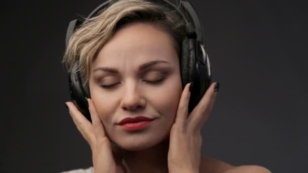 Retrato de hermosa chica en auriculares. Mujer rubia primer plano escuchando música. Joven hermosa chica disfrutando de la música . — Vídeos de Stock