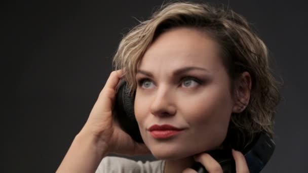 Porträt eines schönen Mädchens mit Kopfhörern. Frau Blondine Nahaufnahme Musik hören. junges schönes Mädchen genießt Musik. — Stockvideo
