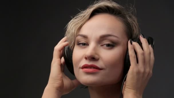 Retrato de hermosa chica en auriculares. Mujer rubia primer plano escuchando música. Joven hermosa chica disfrutando de la música . — Vídeos de Stock