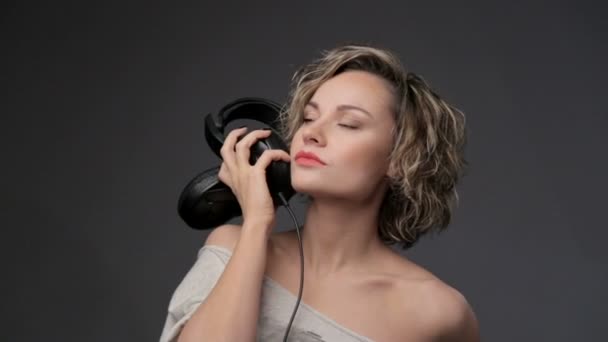 Retrato de hermosa chica en auriculares. Mujer rubia primer plano escuchando música. Joven hermosa chica disfrutando de la música . — Vídeos de Stock