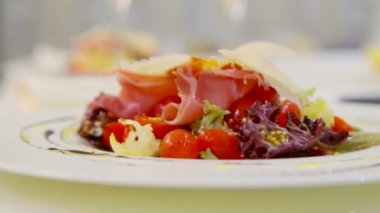 Taze sebze salatası peynir ve domuz pastırması. Marul yaprakları, domates ve peynir. Sebze salatası zeytinyağı ile giyinmiş. Pişirme Sanat.