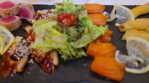 Čerstvé šťavnaté kousky sushi ryb rozloženy na tabuli. Asijská jídla z mořských plodů sushi. Ekologicky čisté rybí jídlo. Gurmánská restaurace. — Stock video