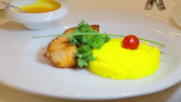 Filets gebratener Fisch mit einer Beilage aus Reis. Gekochter Reis und Fischfilets mit Sauce. Fischgericht mit Reis und Tomaten. — Stockvideo