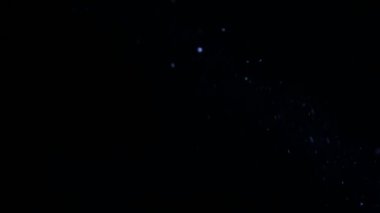 Işık demeti toz. Parlayan ışık demeti küçük parçacıklar. Siyah bir arka plan üzerinde parlayan ortamda bulunan toz tanecikleri. Makro, yakın-up.