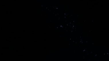 Işık demeti toz. Parlayan ışık demeti küçük parçacıklar. Siyah bir arka plan üzerinde parlayan ortamda bulunan toz tanecikleri. Makro, yakın-up.