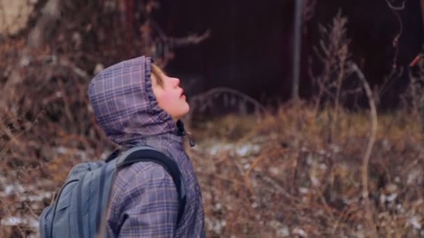 Niño caucásico explora la vieja maquinaria agrícola. Niño adolescente en una granja abandonada en el invierno. La vieja granja. Equipo de granja oxidado . — Vídeos de Stock