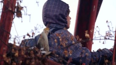 Beyaz çocuk eski Tarım makineleri araştırıyor. Kışın terk edilmiş bir çiftlik çocuk genç. Eski çiftlik. Paslı Tarım makineleri.