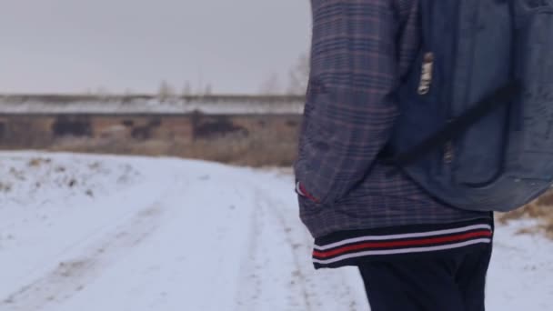 Kavkazská chlapec teenager cestování v zimě. Dítě jde na Zimní silnici přes pole. Cílevědomé teenager překonává po zlém. — Stock video