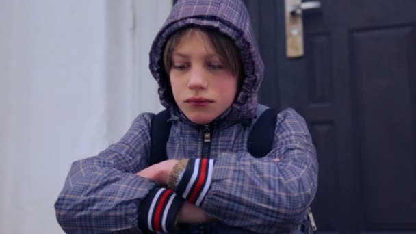 Kaukasiska pojke nära byggnaden av byns skola. Ett barn går och klättrar nära det gamla huset. Country boy tonåring. — Stockvideo