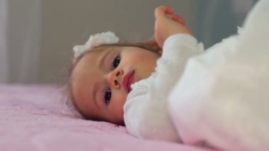 Evde oynamak portre beyaz, küçük kız. Küçük bir kızın yakın çekim portre. Küçük bir kızın duygusal sağlık portresi. Kameraya oynayan yüz yakın çekim çocuk.