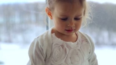 Beyaz, küçük bir kız evde oynamak. Oyuncak ve kitap ile oynayan küçük bir çocuk. Küçük sağlıklı duygusal kız. Aile mutluluk ve sevinç kavramı.