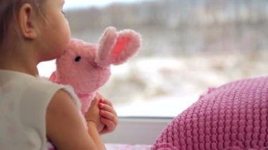 Beyaz, küçük bir kız evde oynamak. Oyuncak ve kitap ile oynayan küçük bir çocuk. Küçük sağlıklı duygusal kız. Aile mutluluk ve sevinç kavramı.