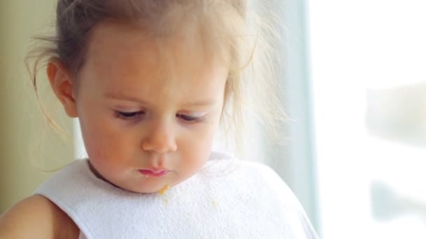 La bambina caucasica mangia indipendentemente. Il bambino piccolo mangia appetitoso. Ritratto di un bambino che mangia il cibo . — Video Stock