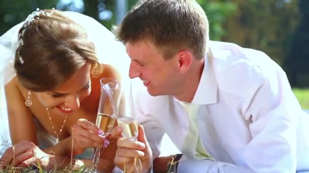 Noiva caucasiana e noivo no dia do casamento bebem champanhe. Amantes, jovem casal nupcial. Jovens casais a divertirem-se. Férias, casamento, felicidade . — Vídeo de Stock