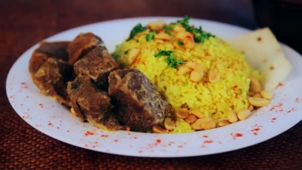 Comida, arroz hervido con carne y cacahuetes. Pilaf árabe con salsa de carne y cacahuetes. Cocina nacional asiática y árabe. Plato de arroz y carne. Pilau, arroz, risotto . — Vídeos de Stock